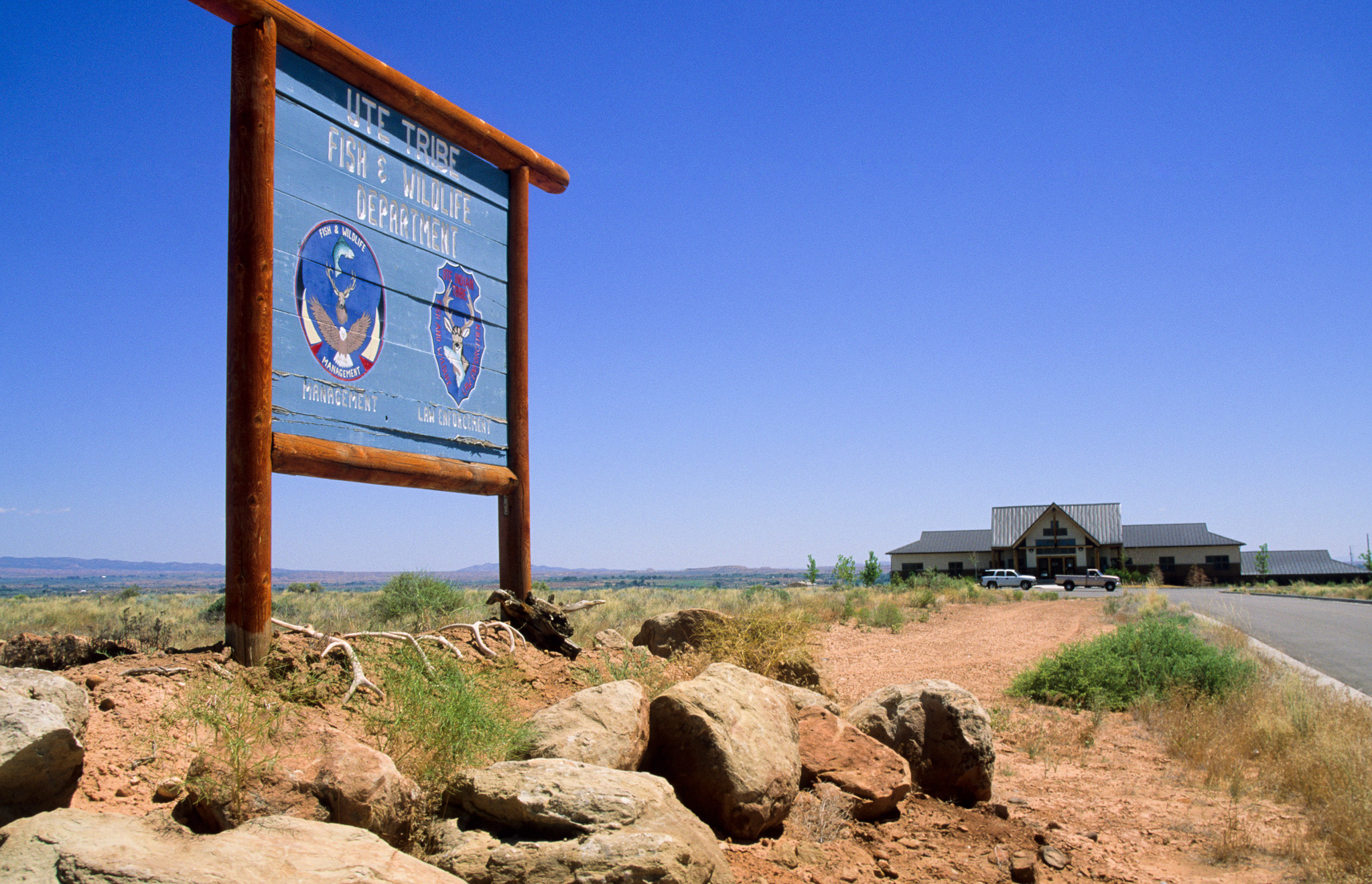 A Ute Tribal Fish and Wildlife sign against a blue sky.